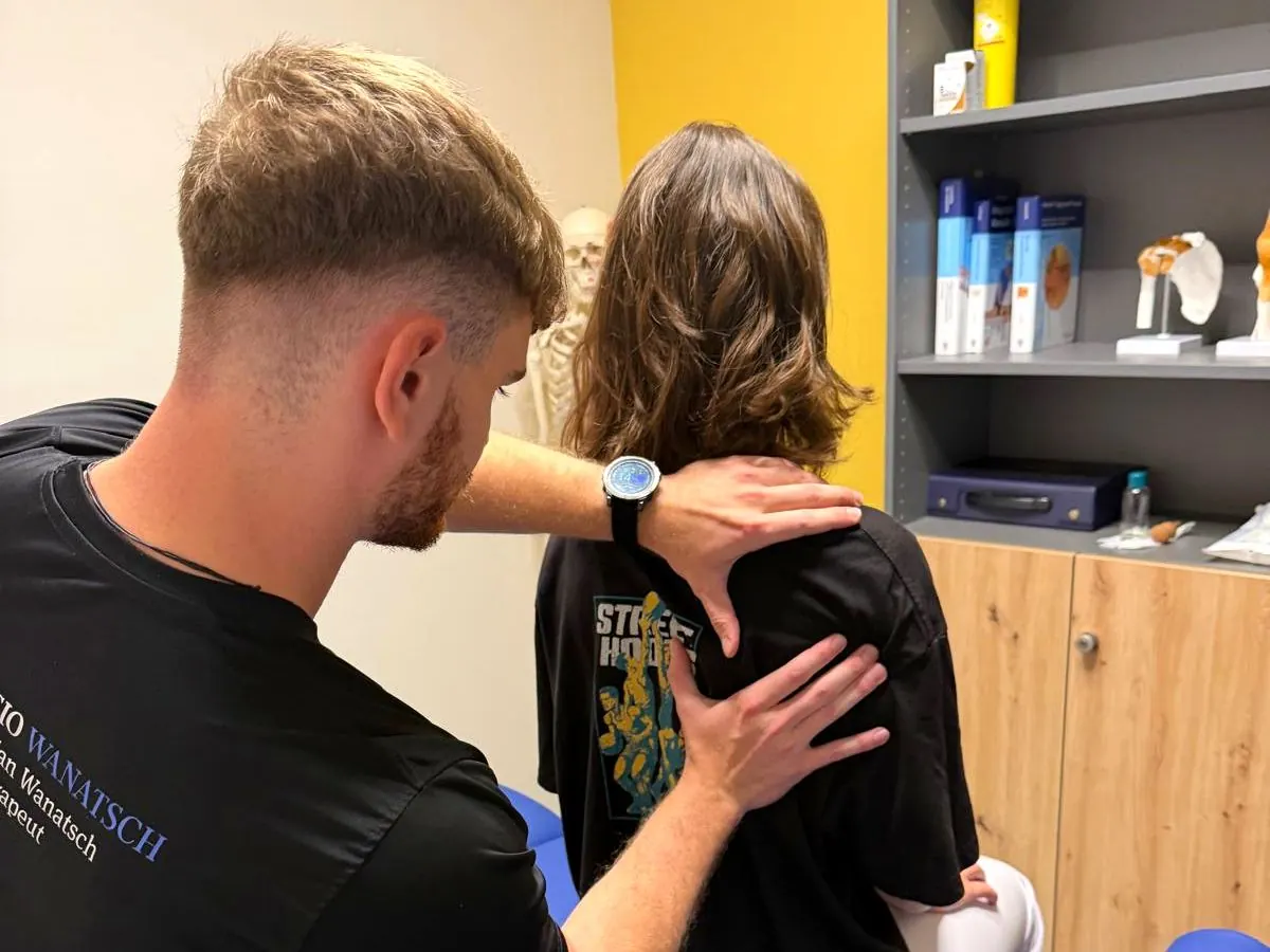 Behandlungsraum mit Therapieliege und anatomischen Modellen
